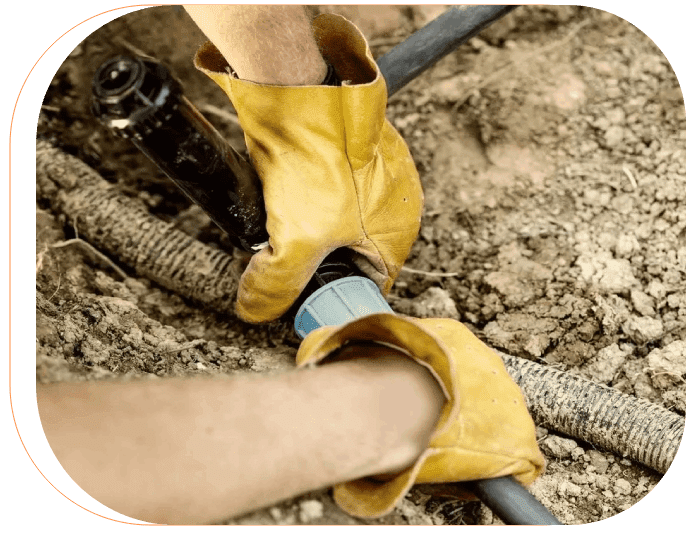 A person wearing yellow gloves holding onto a hose.